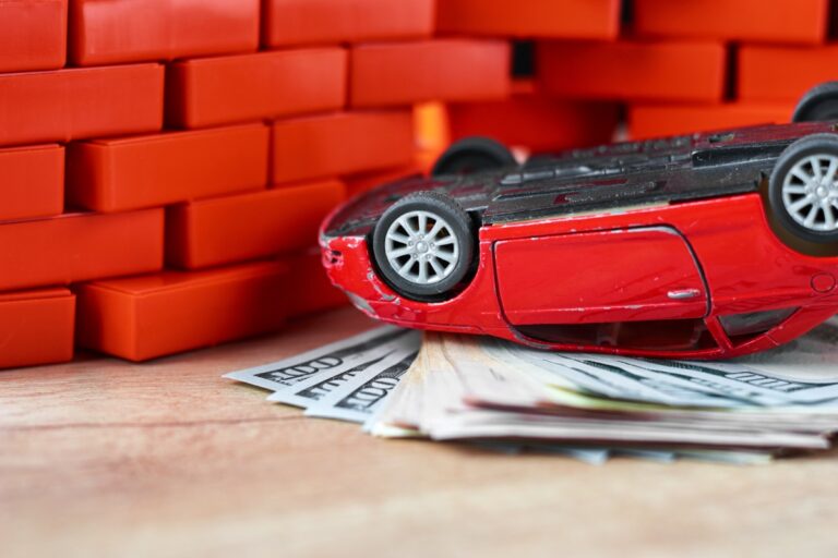 life insurance in a car accident concept. Broken car and dollar banknotes